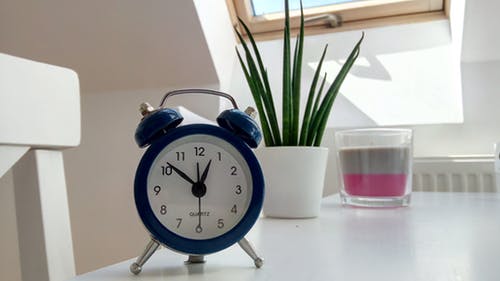 A blue alarm clock on a table.