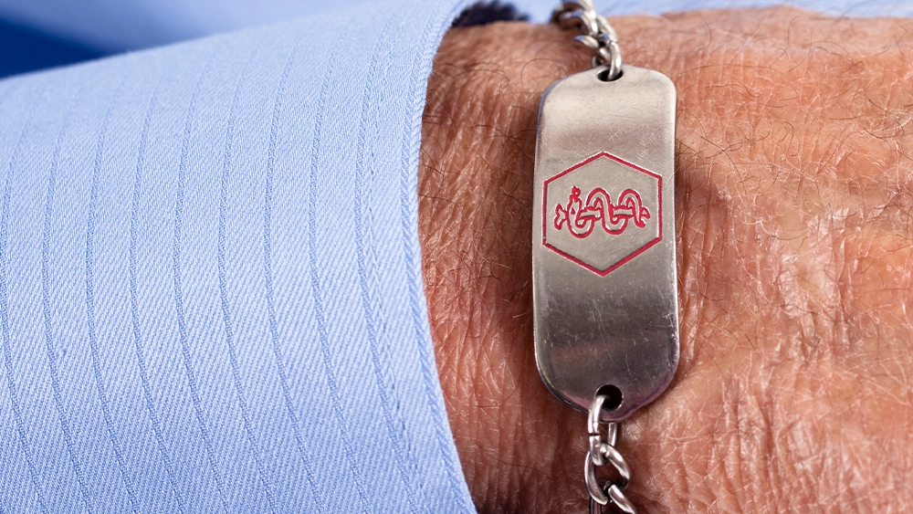 Close up of a man wearing a medical bracelet.