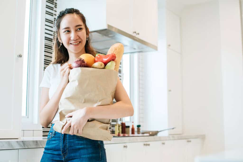 Woman holding plenty of ingredients for cooking