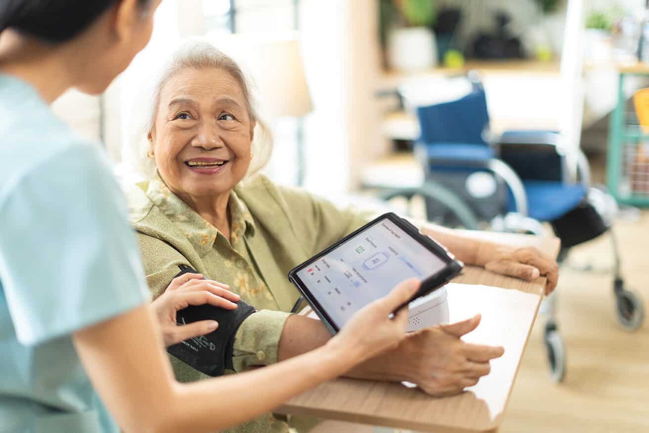Elderly lady smiling while getting her blood pressure taken.
